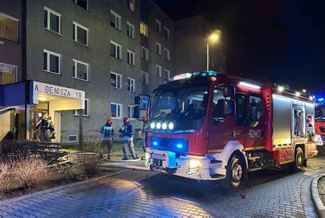 Służby ratunkowe pracujące na miejscu pożaru w bloku mieszkalnym