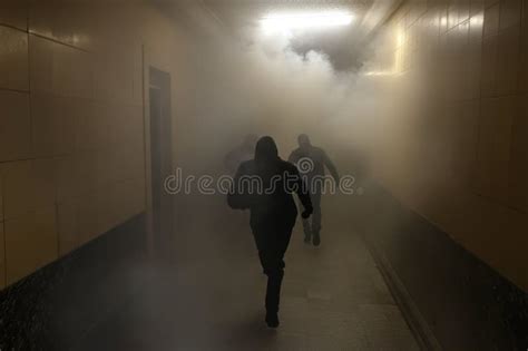 Thematic photo of firefighters evacuating people from a smoke-filled residential building at night