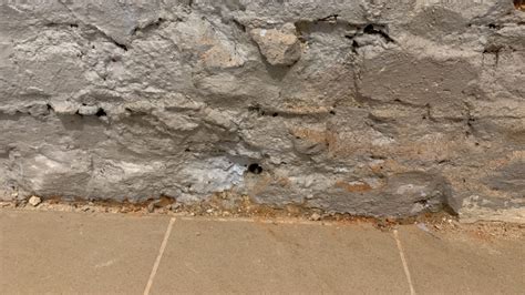 Zdjęcie przedstawiające odpadający tynk na zawilgoconej ścianie