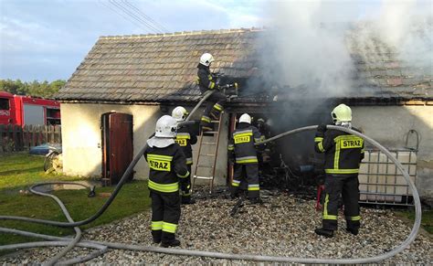 Strażacy gaszący pożar zabudowań gospodarczych