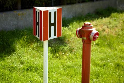 Image of a white and red sign with a black H, indicating an external hydrant