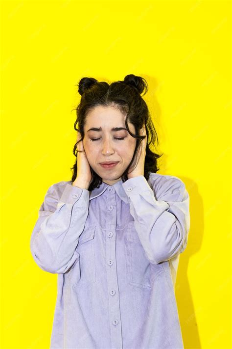 Osoba zakrywająca uszy lub odwracająca się od dzwoniącego alarmu