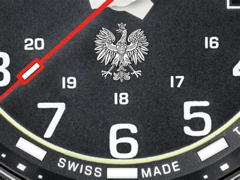 Zbliżenie na tarczę zegarka z wyraźnymi cyframi i motywem wozu strażackiego.