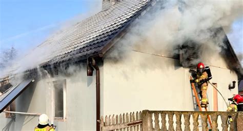 Akcja gaśnicza straży pożarnej przy pożarze dachu domu jednorodzinnego