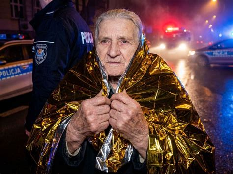 Policjanci ewakuują starszą osobę z płonącego domu