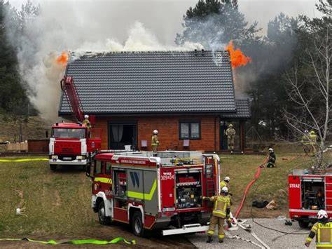 strażacy gaszący pożar dachu domu jednorodzinnego