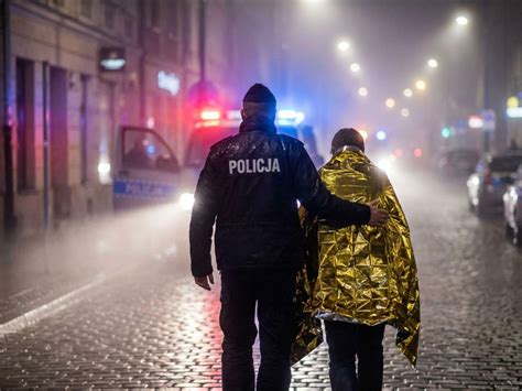 Policjanci ewakuujący poszkodowanego z płonącego budynku