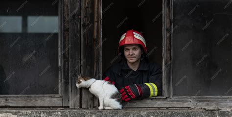 Photo of a firefighter carrying a cat in a transport box during an evacuation