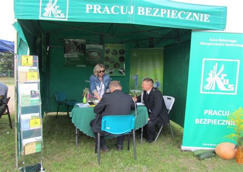 Zdjęcie przedstawiające stoiska informacyjne na wydarzeniu, z widocznymi logo Policji, SOK, KRUS, WCR