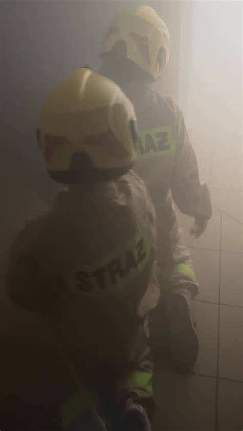Strażak z latarką nahełmową w zadymionym pomieszczeniu