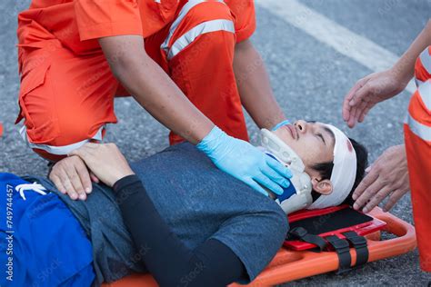 Photo of paramedics assisting injured individuals near an ambulance.