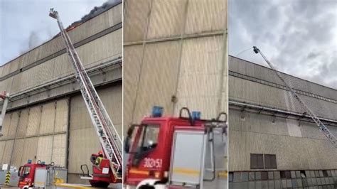 zdjęcie płonącej hali z widocznymi podnośnikami strażackimi