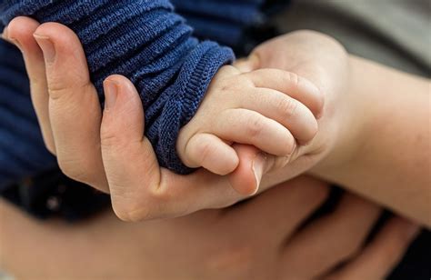 symboliczne zdjęcie dłoni pomagających sobie nawzajem, dłoń dorosłego i dziecka