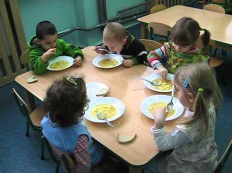 Zdjęcie namiotu stołówki polowej z grupą dzieci jedzących posiłek