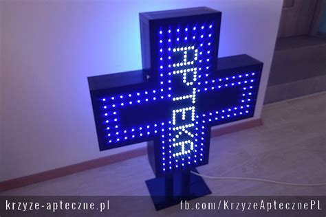 Zdjęcie krzyża aptecznego MONO w nocy, prezentującego tekst