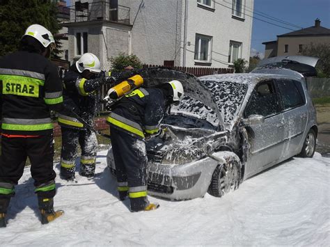 Strażacy z Pasłęka i Zielonki Pasłęckiej podczas akcji gaśniczej na zaśnieżonym polu kukurydzy, gdzie zapalił się kombajn.