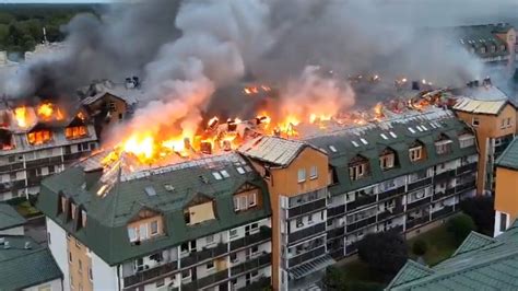 Spalony balkon na tle bloku mieszkalnego z widocznymi śladami ognia