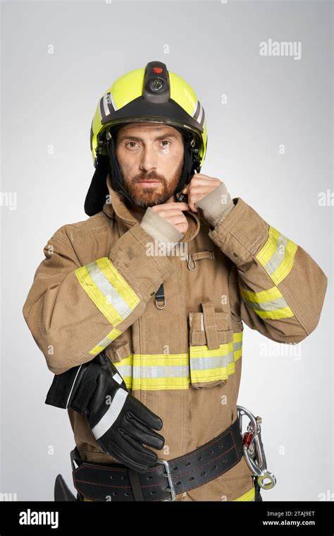 Thematic photo of a male firefighter in uniform looking determined
