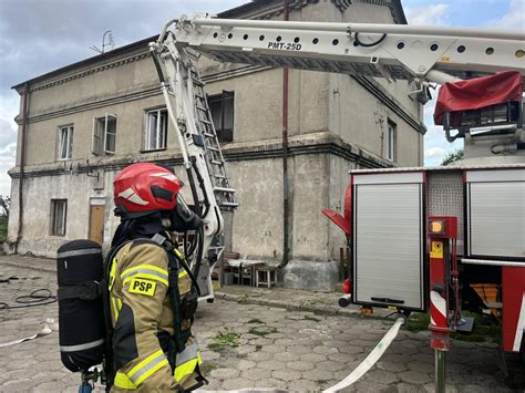 Strażacy OSP Nawsie Brzosteckie w akcji gaśniczej, z widocznymi aparatami ochrony dróg oddechowych wewnątrz budynku