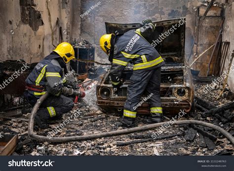 cars and firefighters extinguishing a garage fire