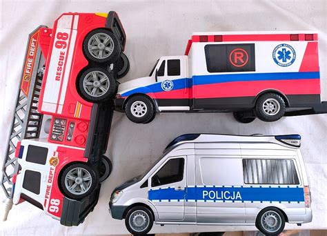 Widok na budynek mieszkalny z oznakami zadymienia, karetka pogotowia, straż pożarna