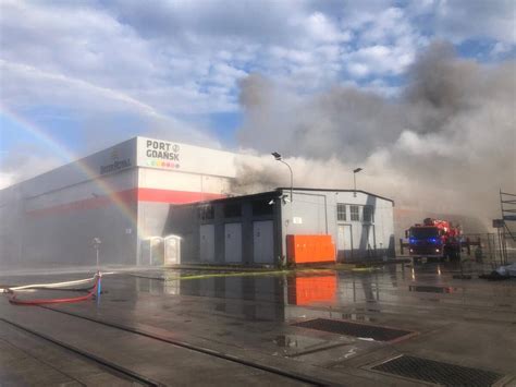 Zdjęcie ukazujące duży pożar w hali magazynowej, kłęby dymu, strażaków w akcji