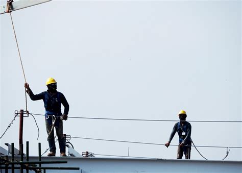 Tematyczne zdjęcie strażaka w uprzęży, przygotowującego się do pracy na wysokości