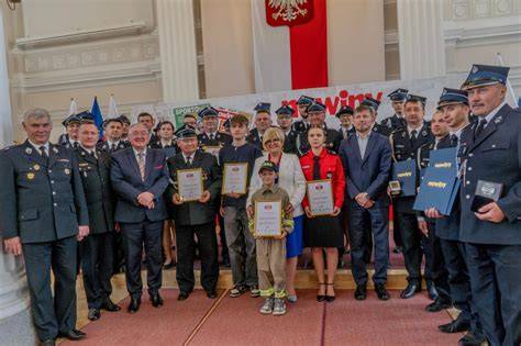 Tematyczne zdjęcie z gali wręczenia nagród Strażak Roku, przedstawiające strażaków odbierających wyróżnienia.