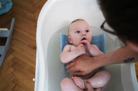 Zdjęcie dziecka w wannie z delikatnie różową wodą lub w kąpieli owsianej