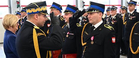Strażak w mundurze galowym podczas uroczystości państwowej, prezentujący odznaczenia