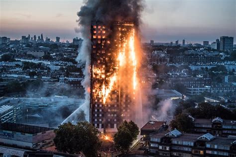 The Grenfell Tower on fire at night, showing flames engulfing the entire building. (Pożar Grenfell Tower w nocy, płomienie ogarniające cały budynek)