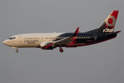 Zdjęcie samolotu Boeing 737-300 Coulson Fireliner w akcji gaśniczej, ukazujące zrzut środka gaśniczego