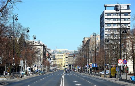 Zabytkowy widok na Aleje Ujazdowskie w Warszawie, z powozami i elegancko ubranymi ludźmi