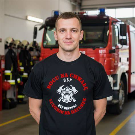 Koszulka OSP z logo jednostki na tle remizy strażackiej