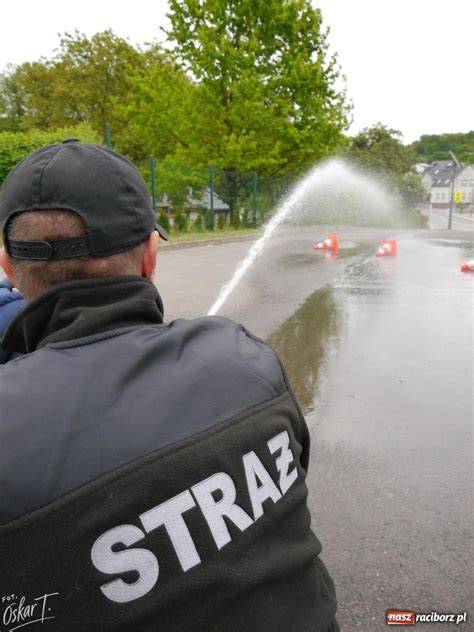 Dziecko w koszulce strażackiej z wozem strażackim w tle
