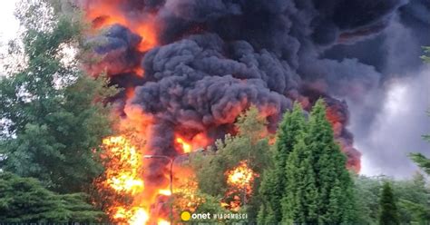 Zdjęcie przedstawiające pożar lasu, płomienie i dym, z helikopterem gaśniczym nad lasem