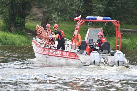 strażacy przeszukujący dno akwenu za pomocą bosaków i kotwicy z łodzi