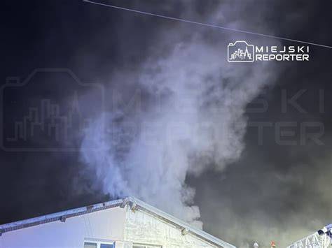 Zadymiony autobus miejski w Elblągu, z widocznymi strażakami gaszącymi pożar