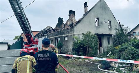Zdjecie domu jednorodzinnego w nocy z wozami strazy pozarnej