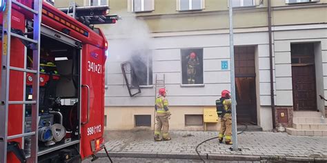 Strażacy gaszący pożar mieszkania w Wałczu, widoczne wozy strażackie