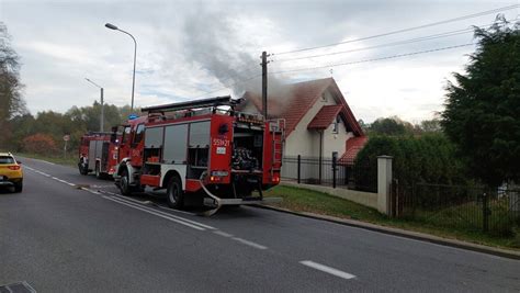 Zastępy straży pożarnej gaszące pożar domu i samochodu