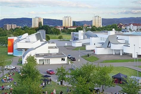 Panorama Vitra Campus w Weil am Rhein, prezentująca różnorodność stylów architektonicznych budynków.