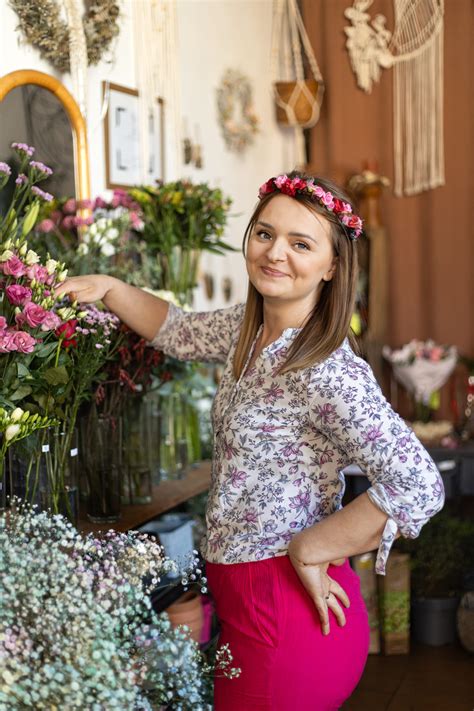 florystyczna pracownia z mnóstwem kwiatów i narzędzi, kobieta układająca bukiet