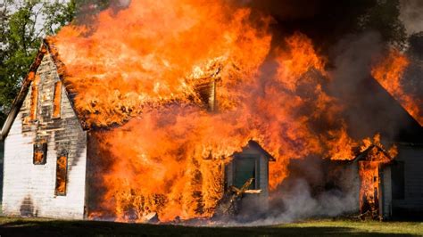 zdjęcie przedstawiające pożar budynków inwentarskich, płomienie i zadymienie