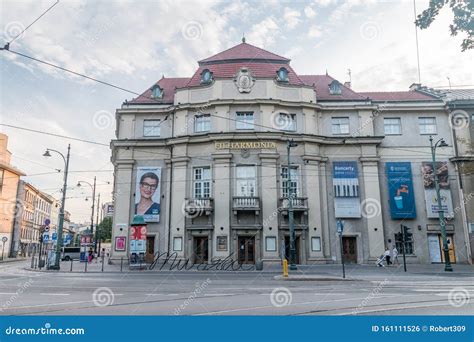 Thematic photo of the Krakow Philharmonic building under renovation, with a hint of smoke or emergency services present