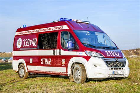 Zdjęcie przedstawiające zespół ratowników OSP GRS Starówka przy swoich pojazdach operacyjnych