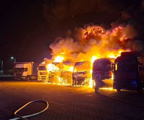 zdjęcie płonących ciężarówek na parkingu