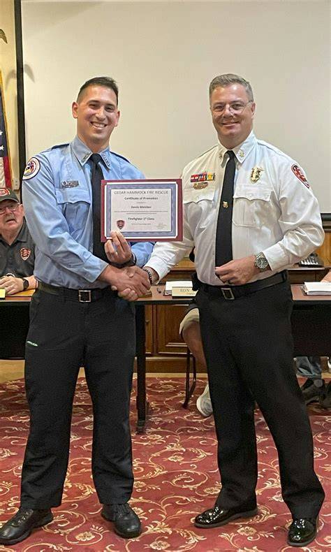 Photo of a firefighter promotion ceremony, with officers in uniform receiving awards or congratulations.