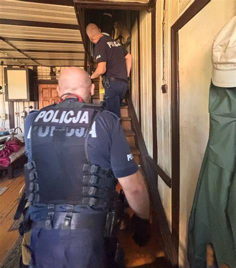 Policjanci ewakuujący rodzinę z zadymionego domu