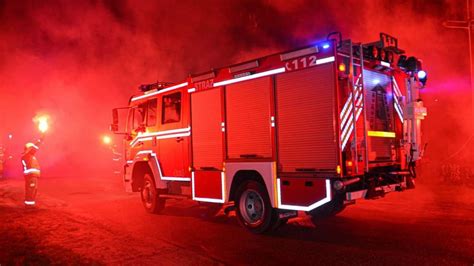 Wóz strażacki przed płonącą kamienicą